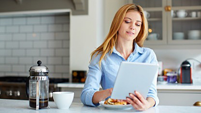 Lady using tablet in kitchen