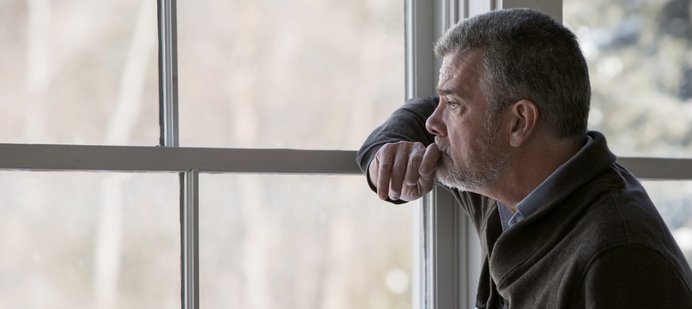 Grieving man at window